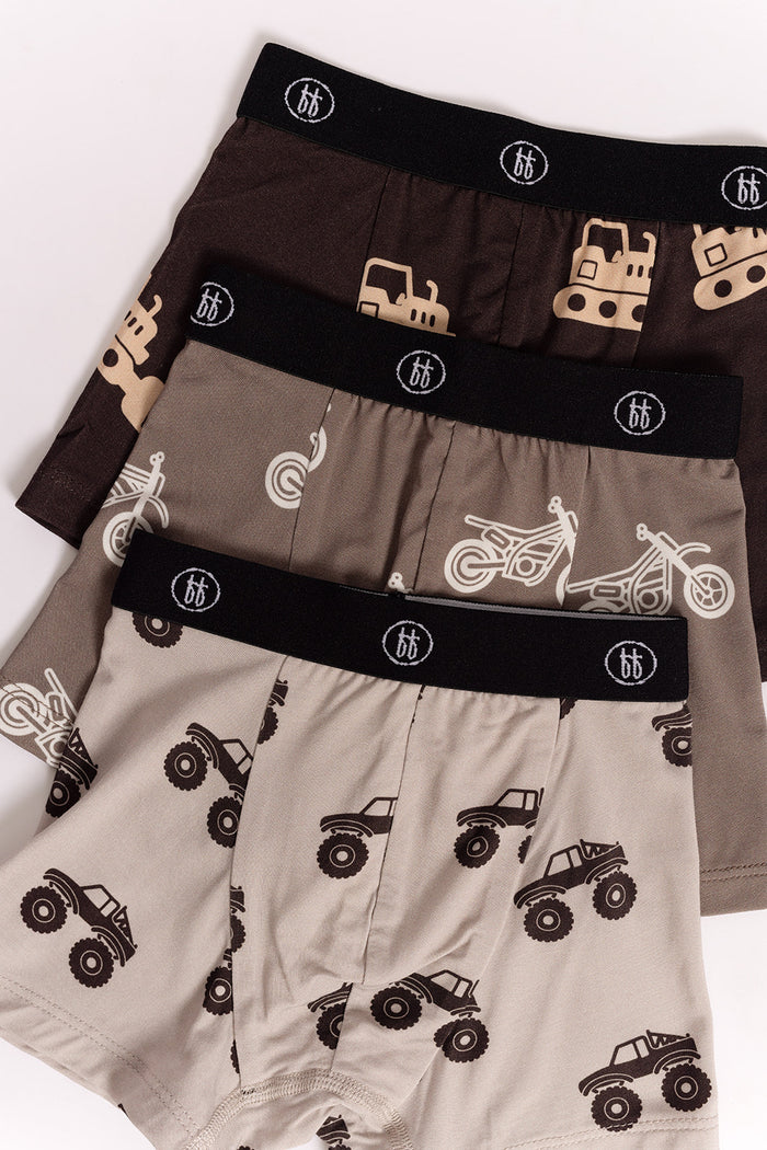 The forever french baby Bamboo Boxers (3 Pack) include hypoallergenic boys’ underwear with black logo waistbands and fun prints: construction vehicles on brown, motorcycles on taupe, and monster trucks on beige.
