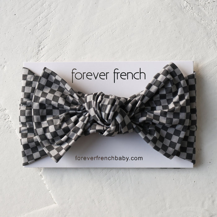 The Bamboo Head Wrap | Street Micro Check by forever french baby is shown on a branded card with "foreverfrenchbaby.com" against a textured white background. The headband features a black and white checkered pattern.