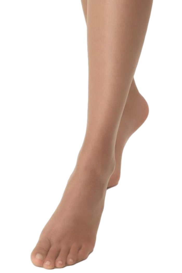 Close-up of a person's feet wearing sheer beige hold ups on a white background