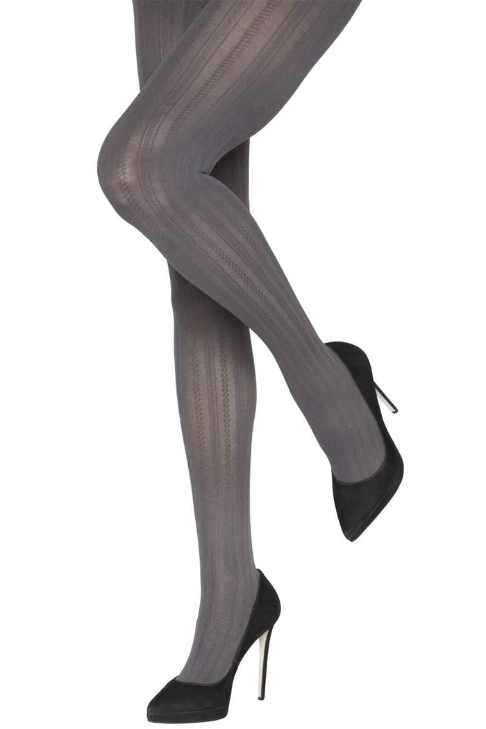 Cable patterned tights worn by a person with black high-heeled shoes on a white background