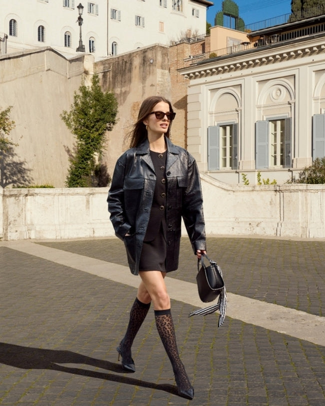 Woman wearing falke leopard socks with black dress and jacket