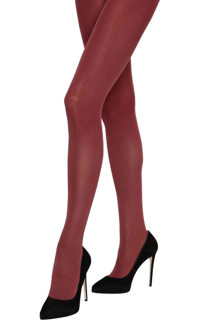 Red Charnos tights worn by a person with black high heels on a white background