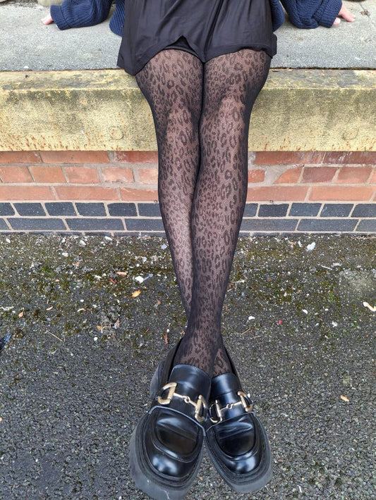 model wearing pretty polly animal print tights with black loafer shoes