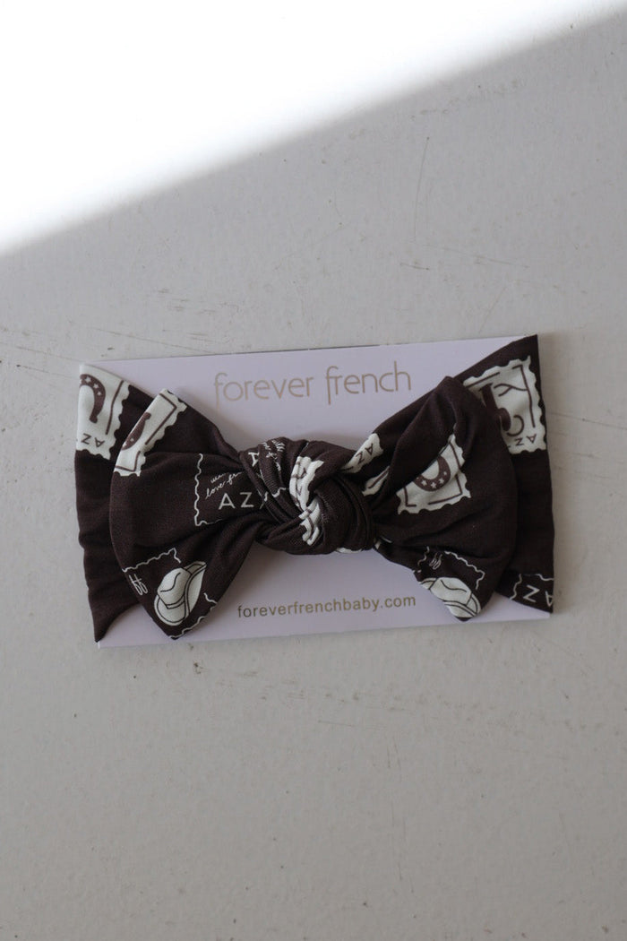 The Bamboo Head Wrap | With Love from AZ by forever french baby features black bamboo fabric with white map and letter designs, tied in a bow, and is displayed on a branded card with foreverfrenchbaby.com on a light surface.
