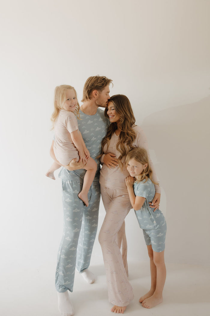 A family of four smiles together in coordinated pastel Kendy 3 Women's Bamboo Pajama | Ruby sets—soft, stylish sleepwear ideal for breastfeeding moms—set against a plain light background.