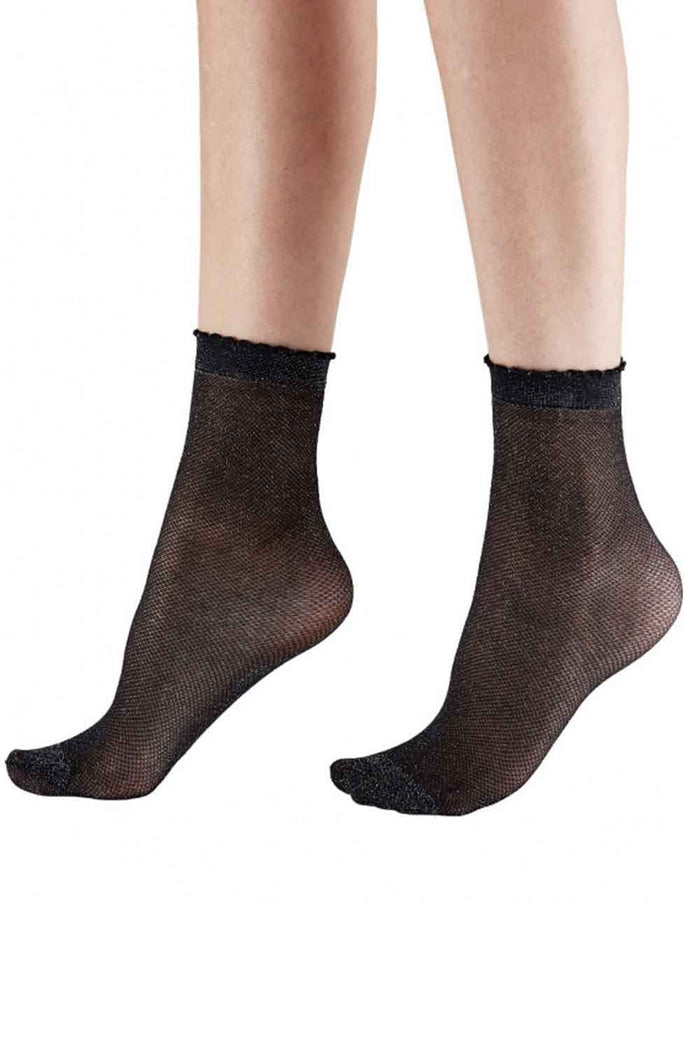 Black sheer  black and silver sparkle socks worn by a person on a white background