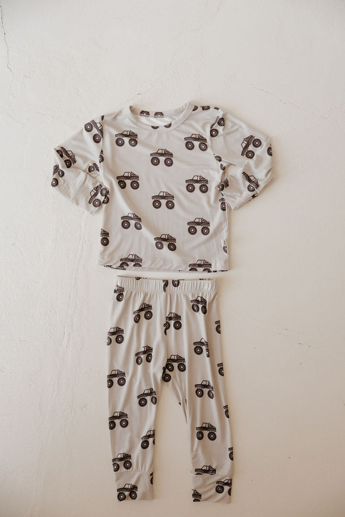 The Bamboo Footless Sleepy Time Set | Monster Truck by forever french baby is a two-piece children’s pajama set in light gray with black monster truck print, made from hypo-allergenic bamboo, featuring long sleeves and pants.