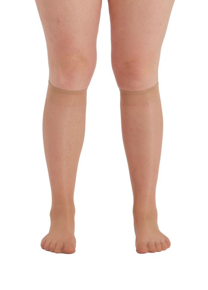 Nude  knee-high socks worn by a person on a square  background