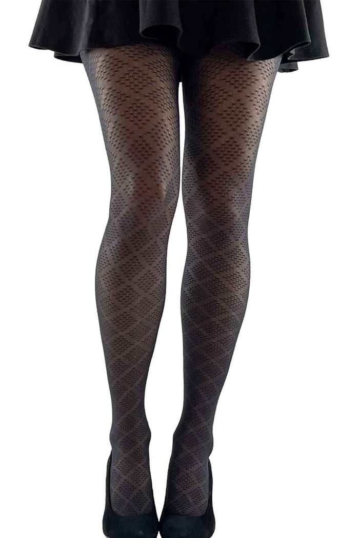 Black diamond patterned tights worn with a black skirt on a white background