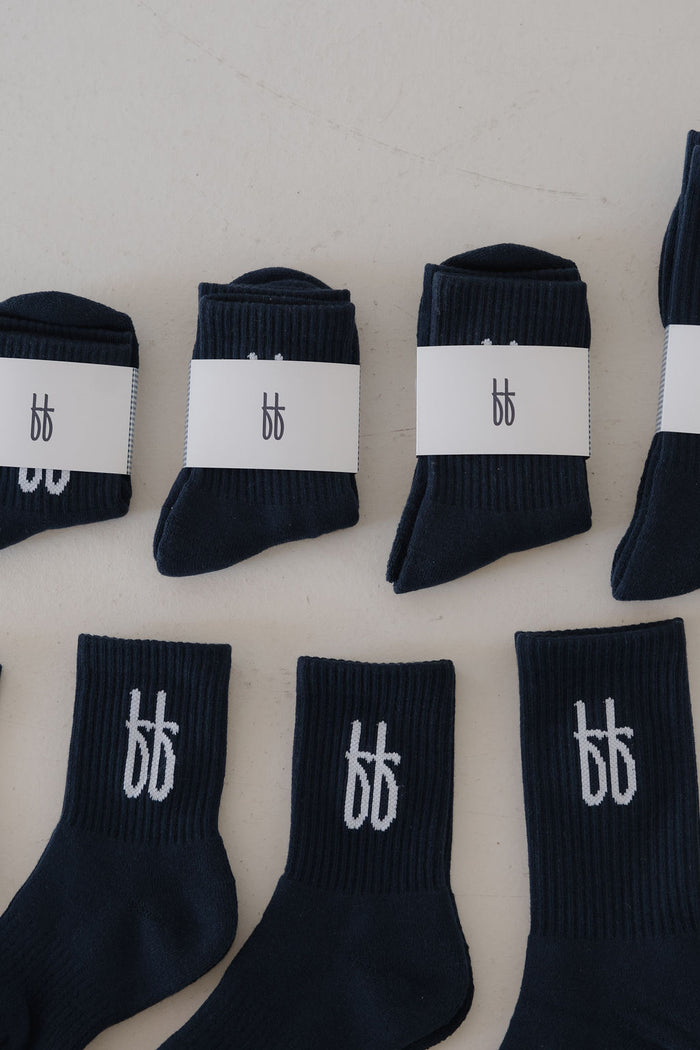 Multiple pairs of ff Crew Socks | Navy from forever french baby, each featuring a white "bb" logo, are displayed on a light surface. Some are folded and wrapped with matching white "bb" logo labels.