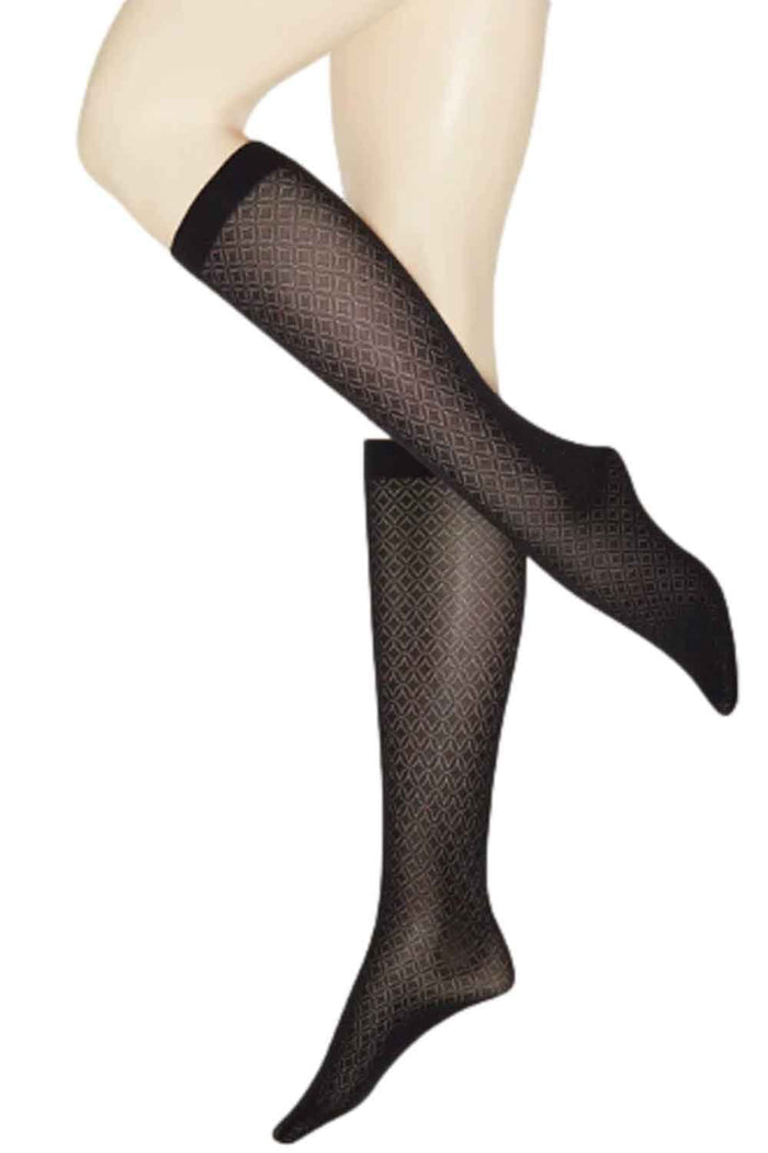 Black geometric patterned knee highs worn by a model on a white background