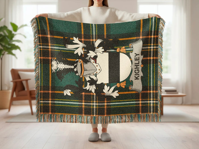 Plaid throw blanket with Kighley crest held by a person.