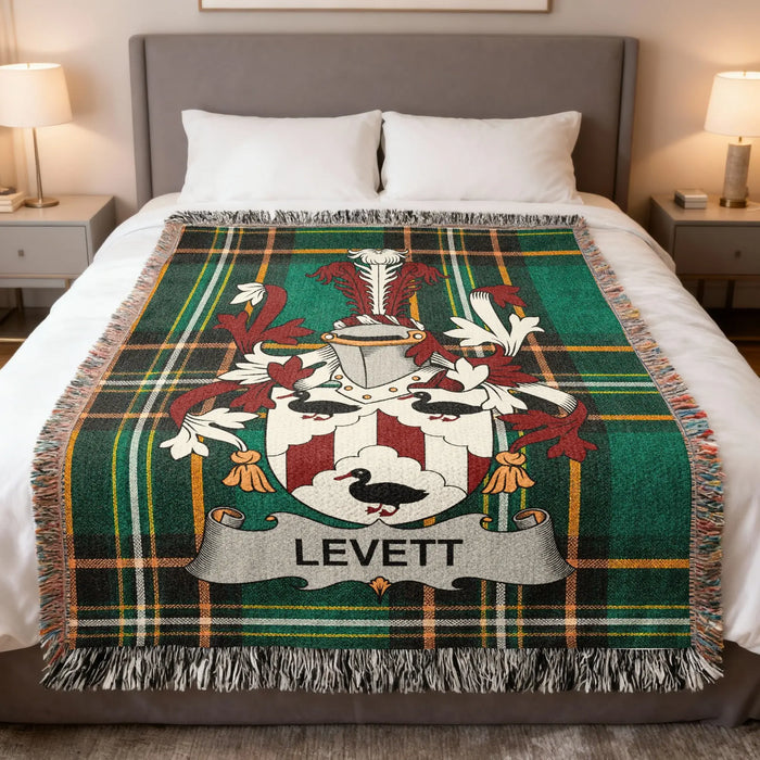 Levett family crest woven blanket arranged on a made bed.