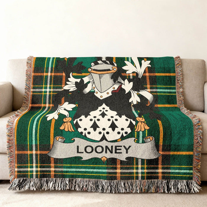 Green plaid throw blanket featuring a coat of arms with the name "LOONEY."