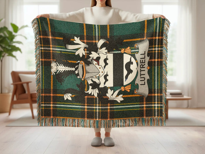 Tartan blanket with a shield crest and "Luttrell" text, held by a person.
