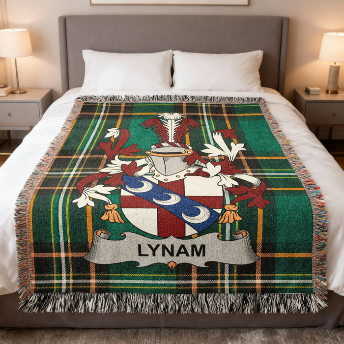 Tartan blanket with Lynam family crest on a bed.