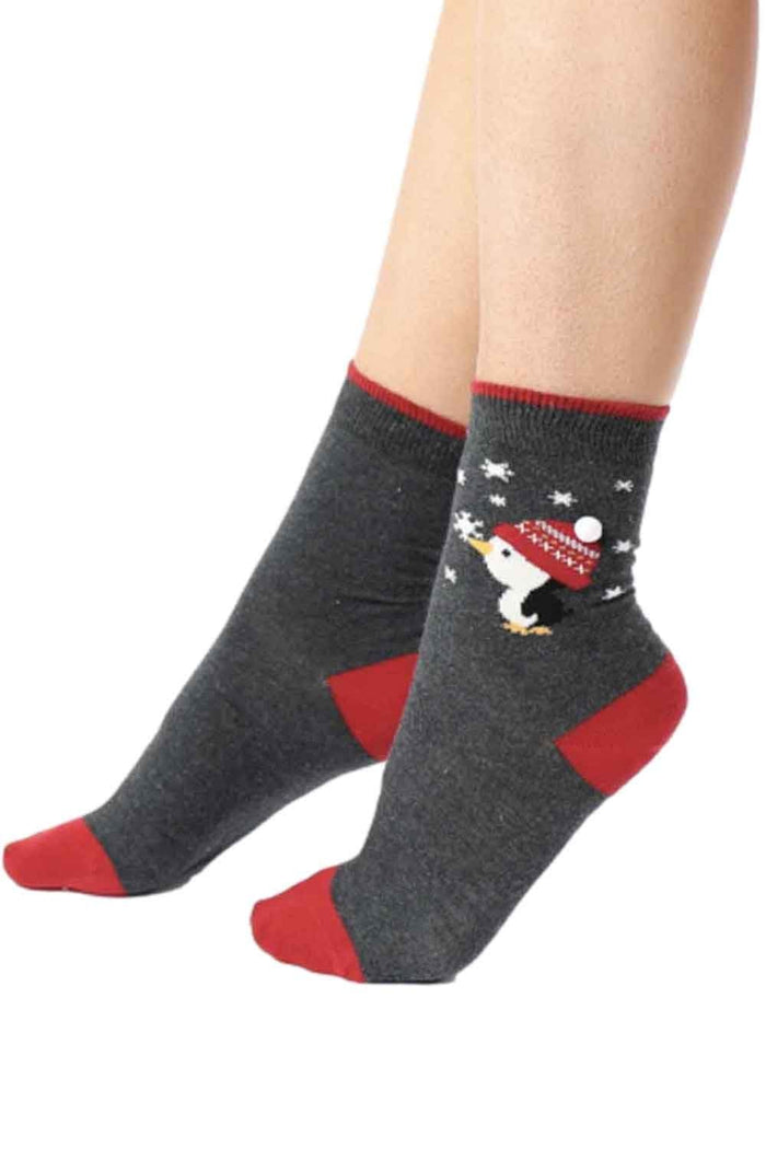 Gray and red socks with penguin  worn by a person on a white background