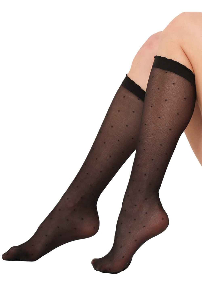Black knee-high socks with dot pattern worn by a person on a white background