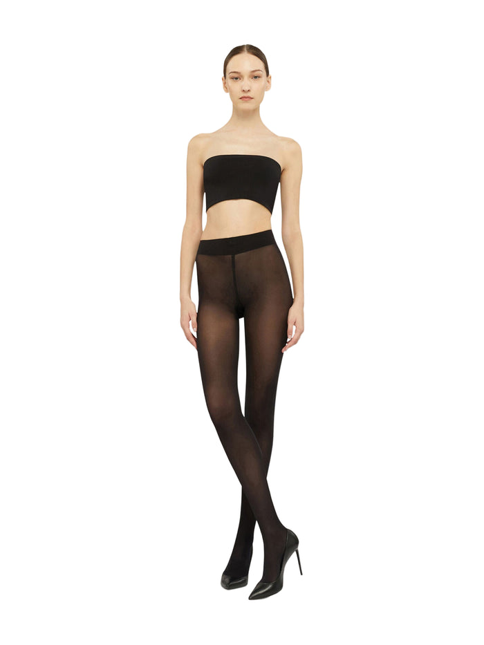 Woman wearing black strapless top and Wolford opaque black tights on a white background