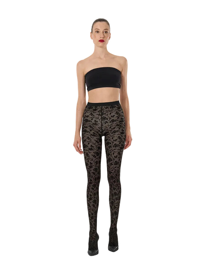 Model wearing black strapless top and patterned leggings on a white background