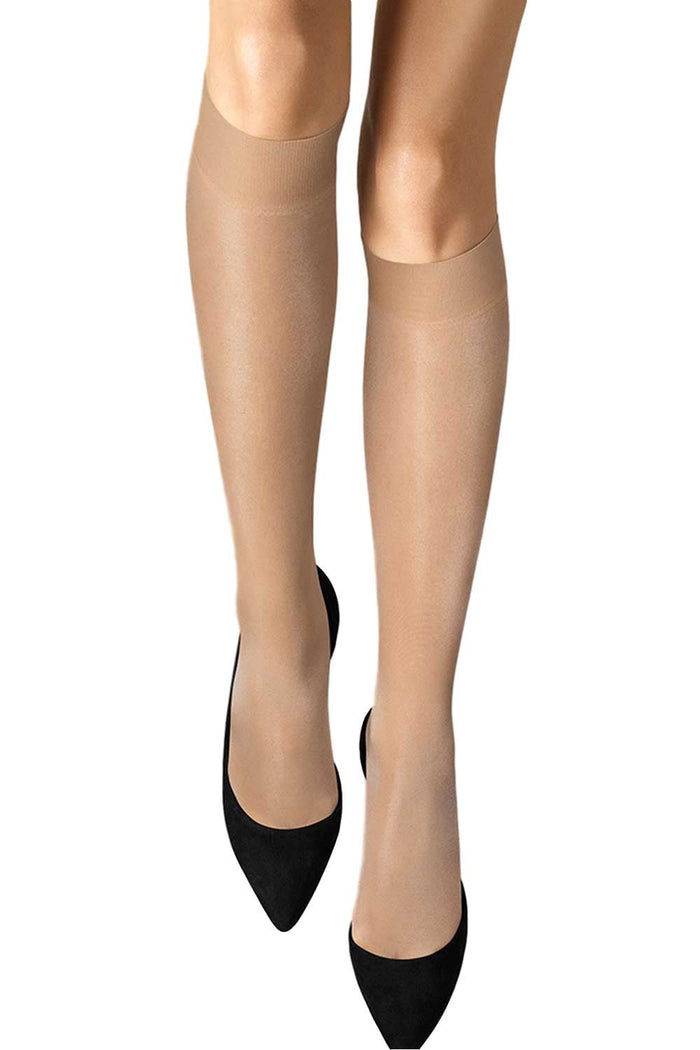 Wolford fairly light knee highs worn with black high heels on a white background