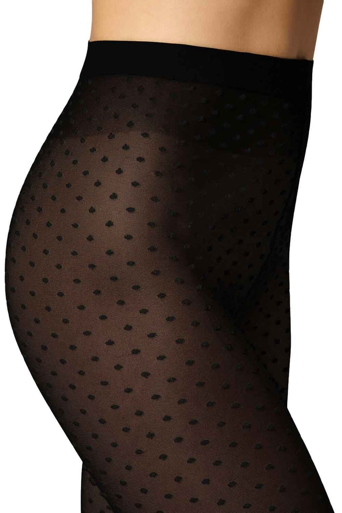 Black polka dot tights worn by a model on a white background