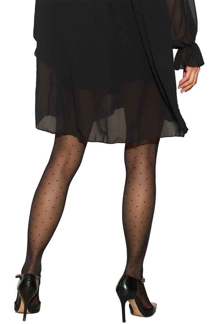 Model wearing a black dress and Allana polka dot tights on a white background