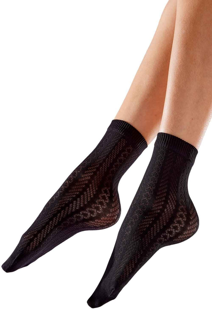 Black socks with a subtle pattern worn by a person on a white background