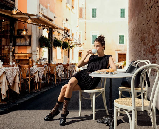 model in Paris summer setting wearing black dress with falke fishnet socks and loafers